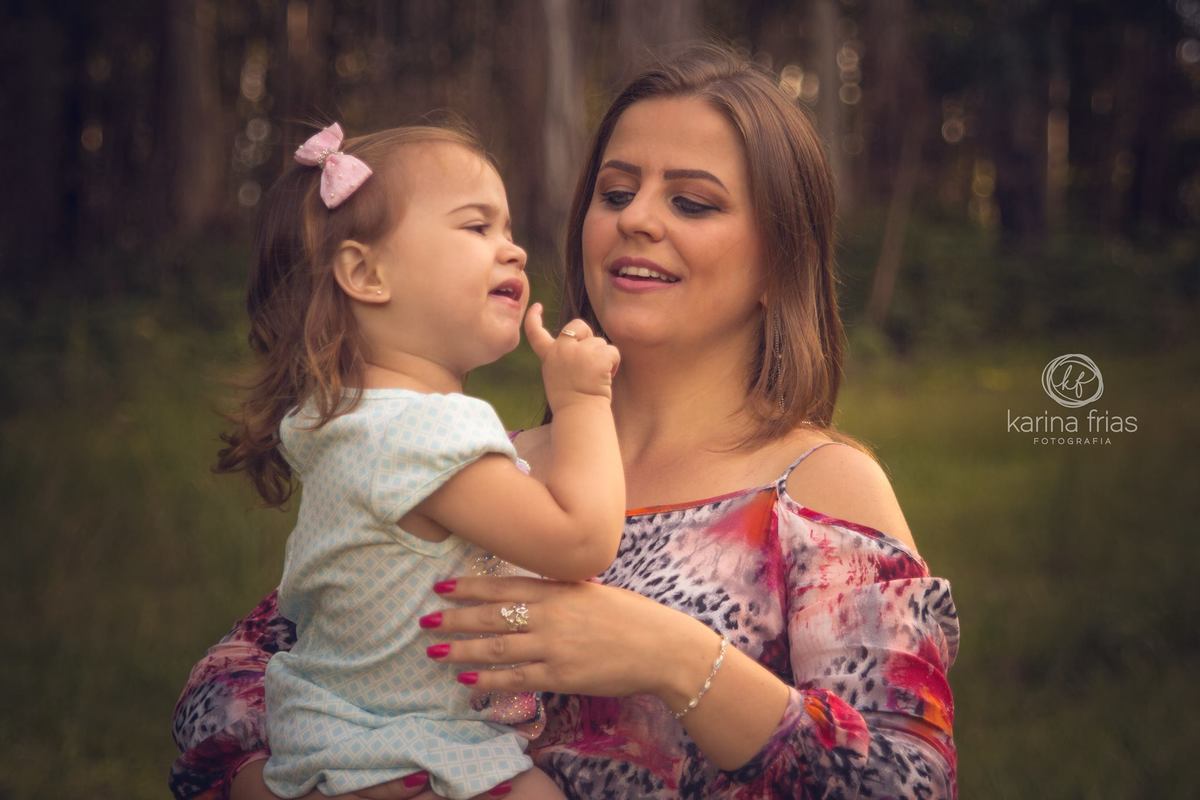 A mãe acalenta a criança para o ensaio externo de familia