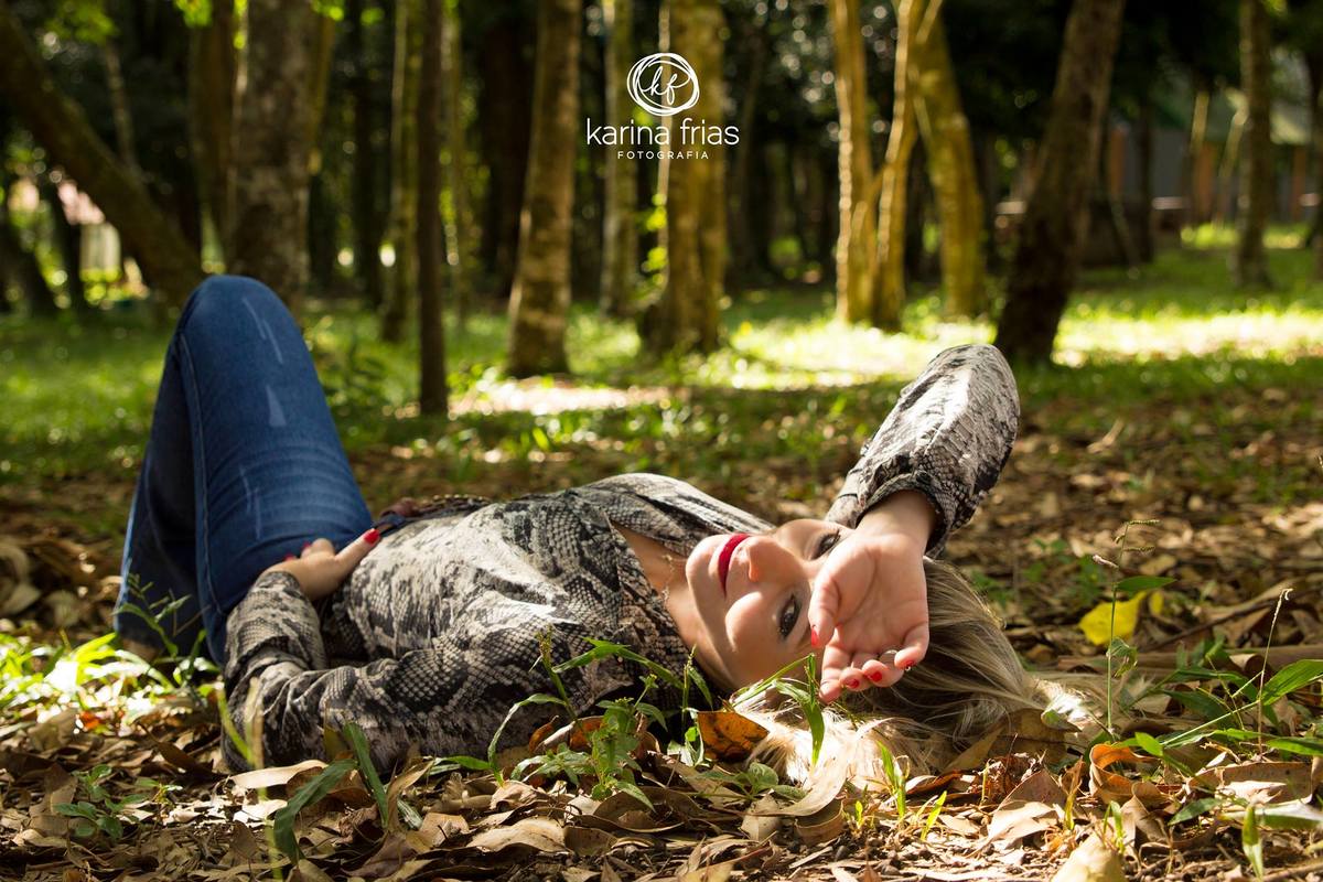 Deitada, a modelo se ajeita para as fotos externas de seu ensaio fotografico