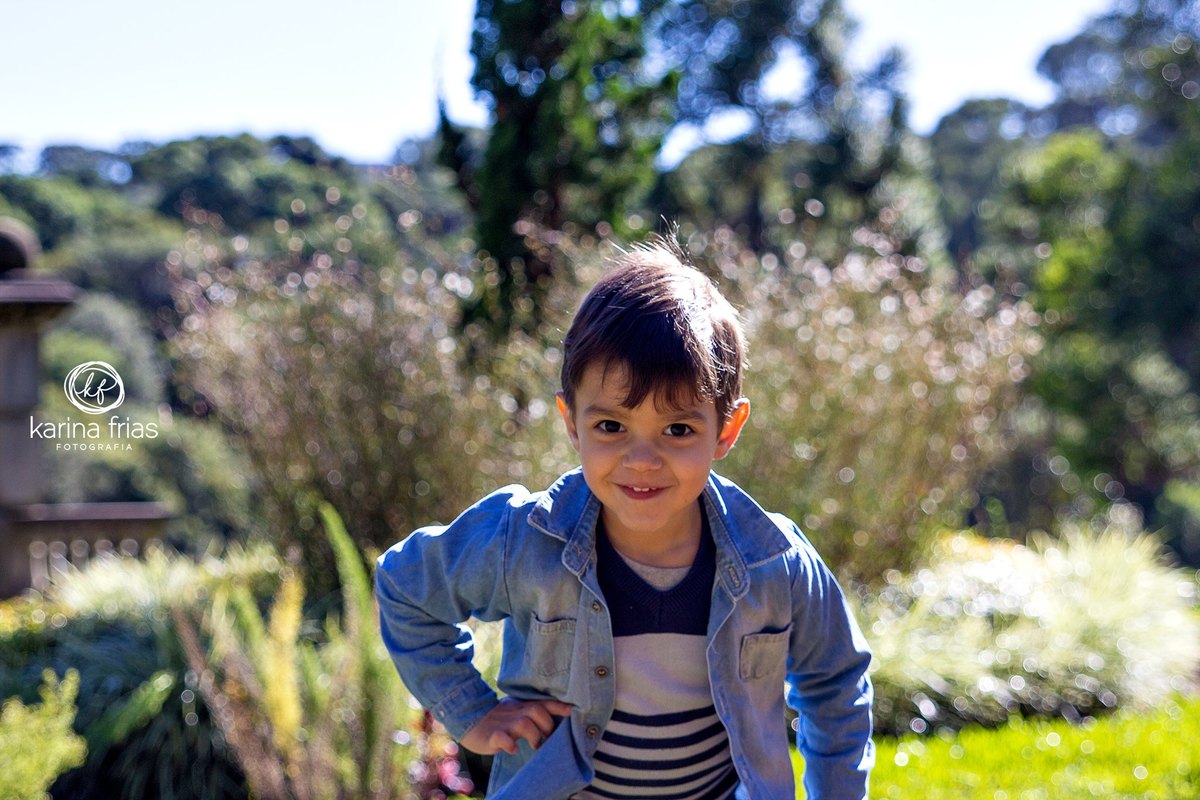 a criança faz pose para as lentes da fotografa de familia, karina frias