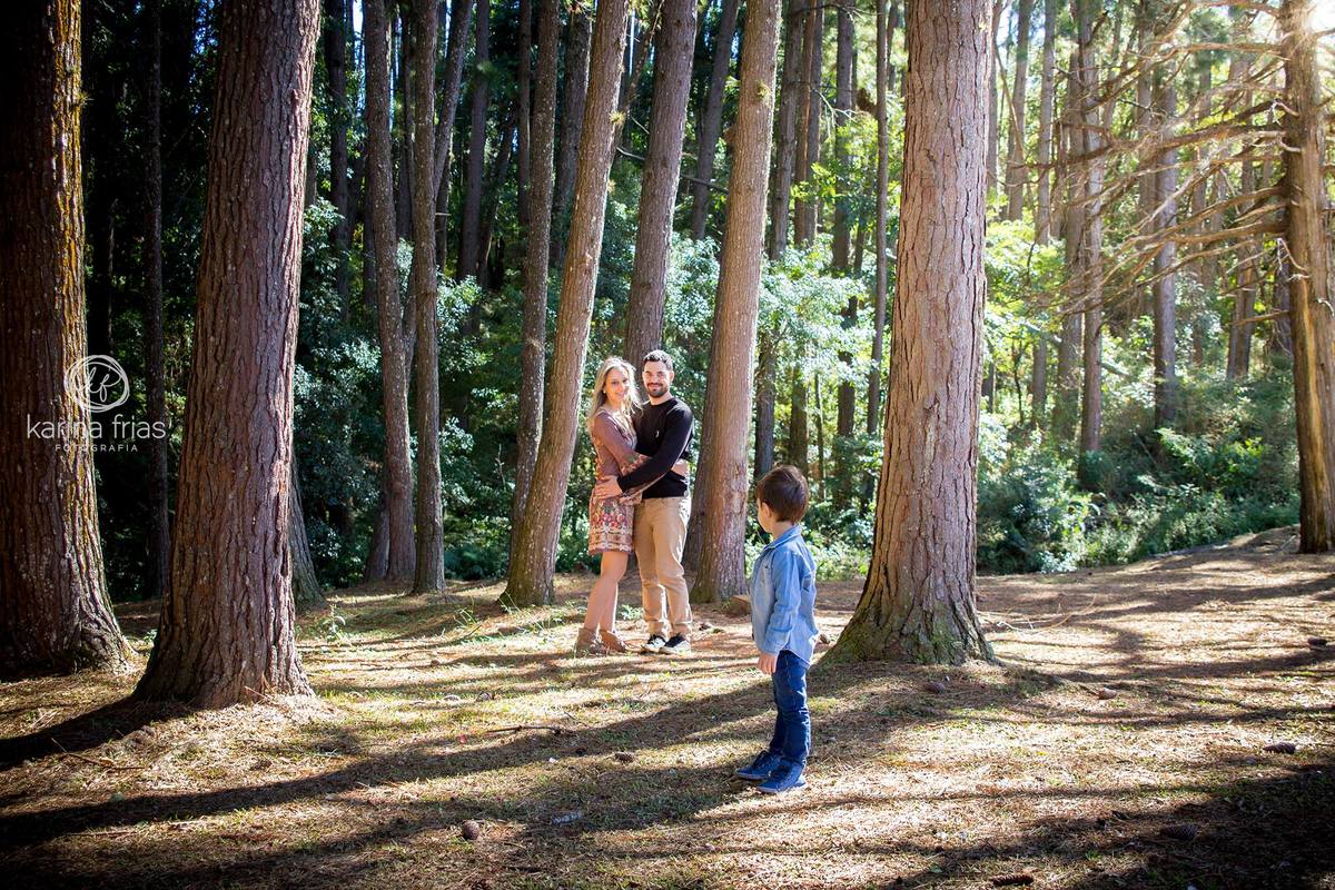 Filho observa os pais fazendo pose para a fotografa de familia de caxias do sul