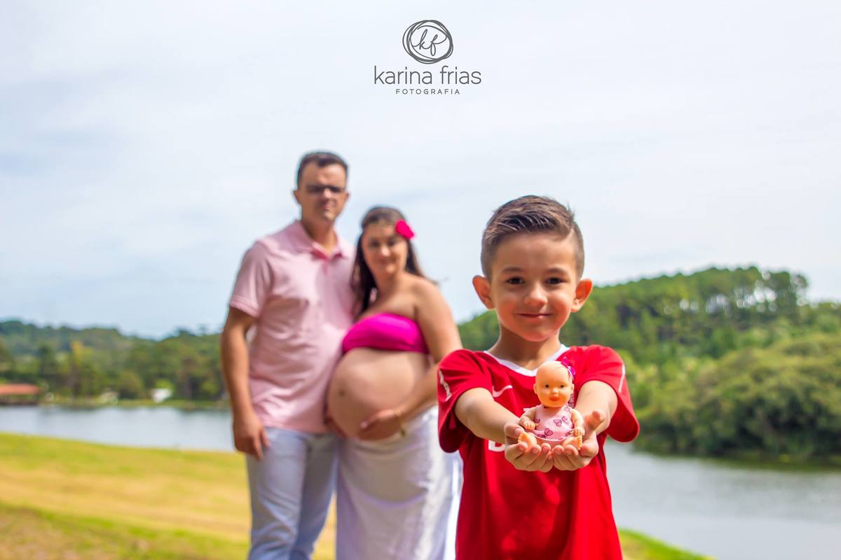 o filho mostra a boneca da irma no ensaio gestante da mãe