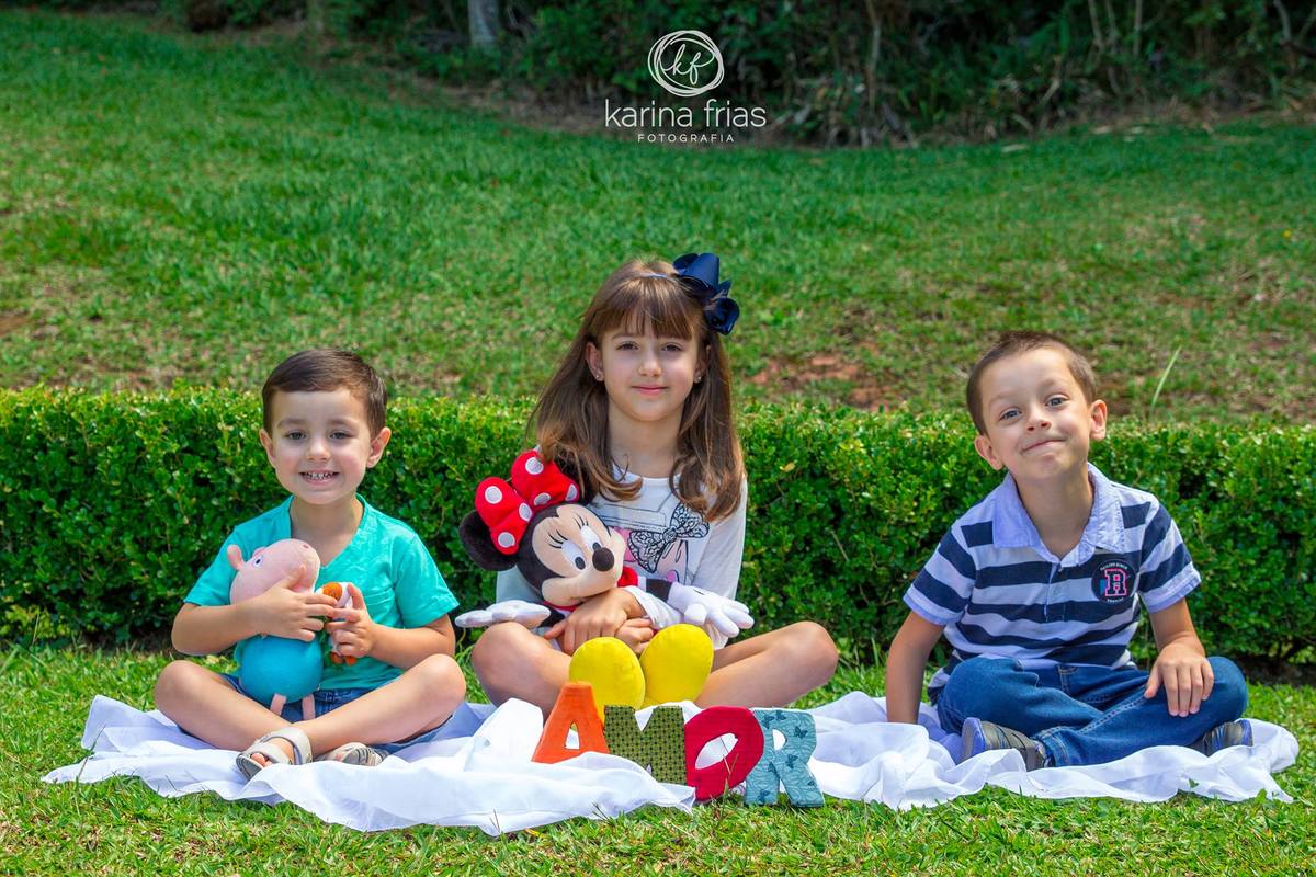 O trio esta sentado em seu ensaio externo infantil