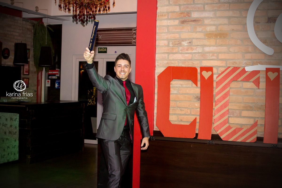 Na festa de formatura, o formando acena para os convidados