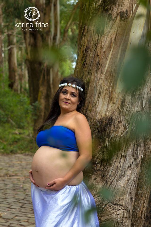 a gestante sorri em seu ensaio externo