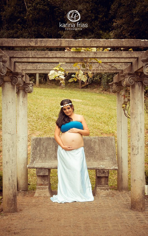 Ana segura a barriga em seu book de gestante.