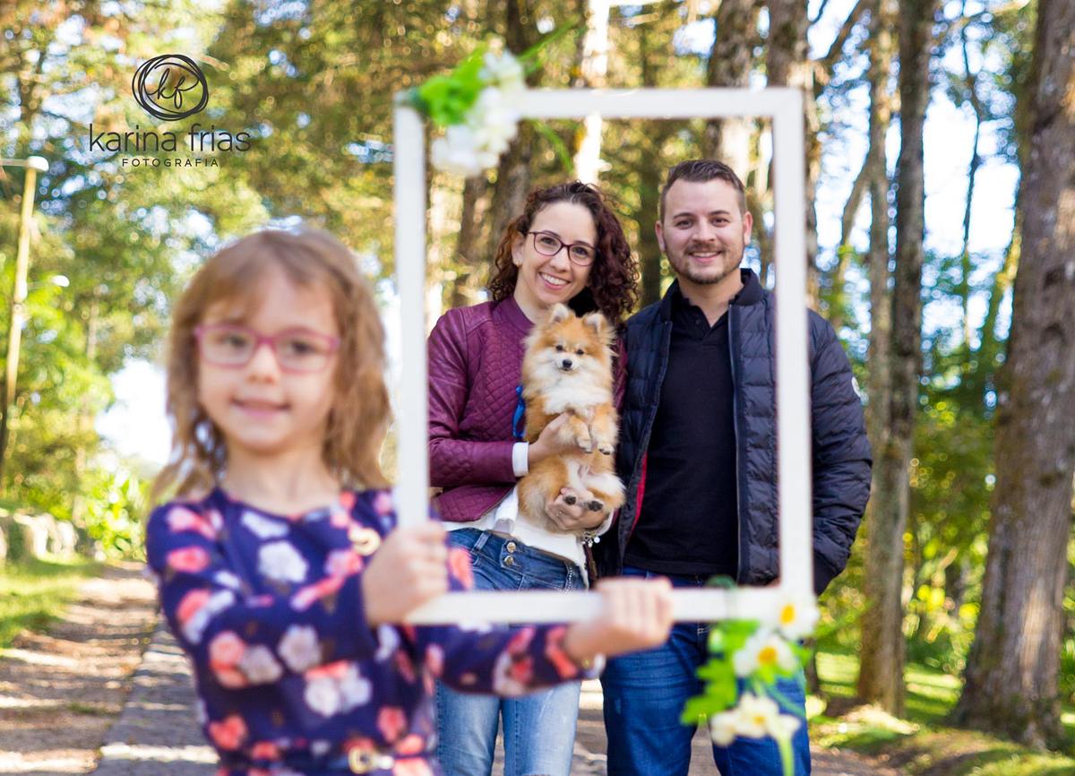 A filha mostra os pais dentro do quadro para as fotos do book de familia externo