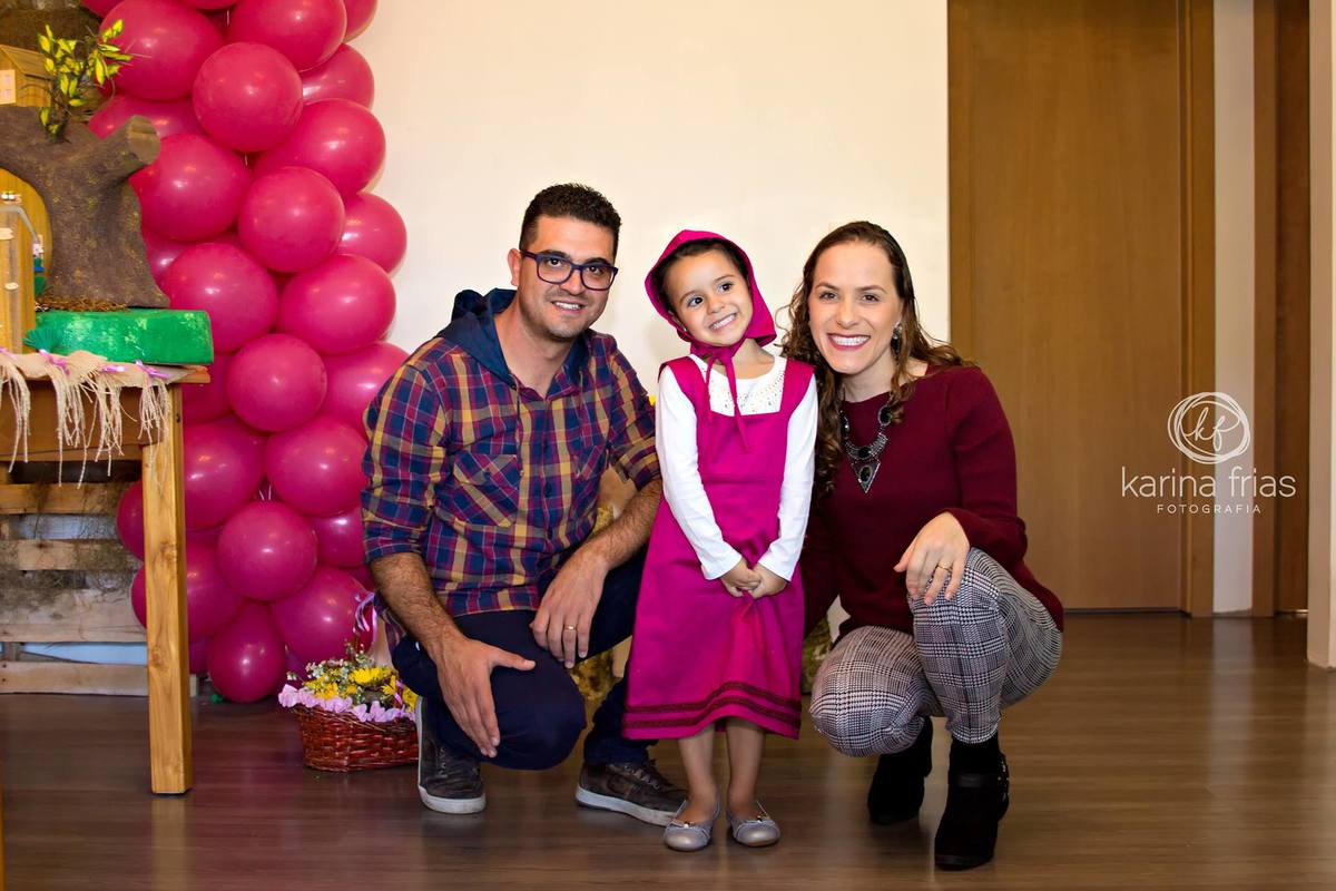 a aniversariante tira um tempo da sua festa de aniversário para tirar uma foto com sua família