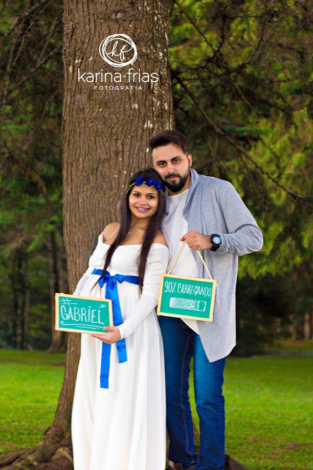 a fotógrafa karina do ensaio de gestante faz os modelos segurarem placas e olharem para ela