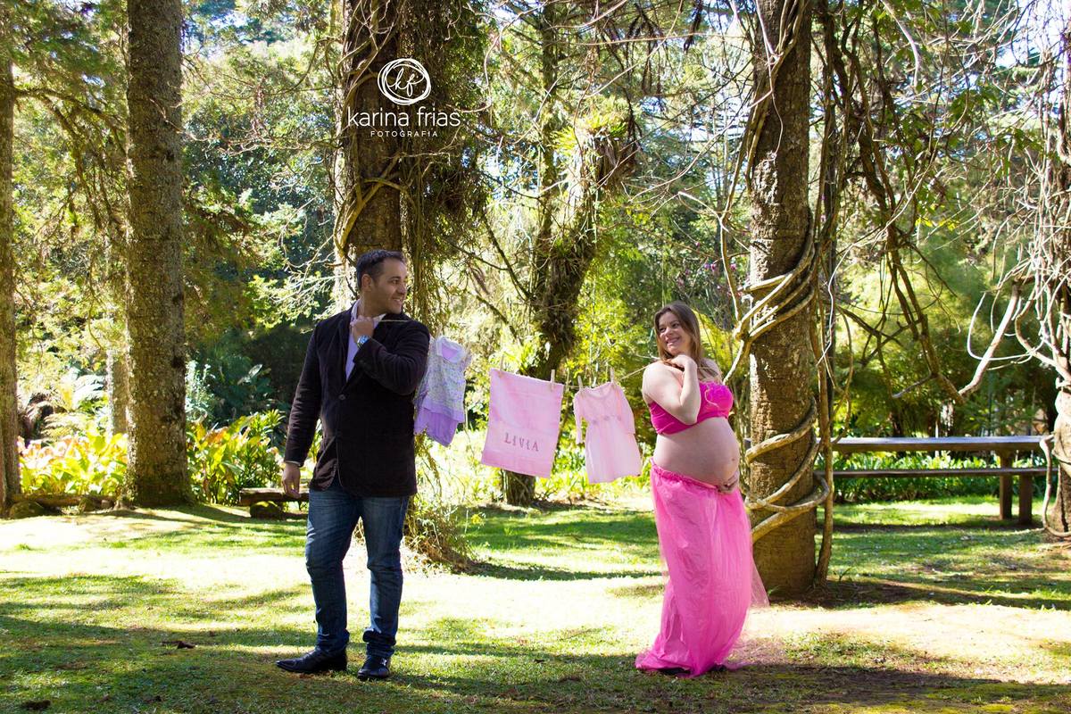 os pais compram roupas para o ensaio de gestante externo e as põe no varal