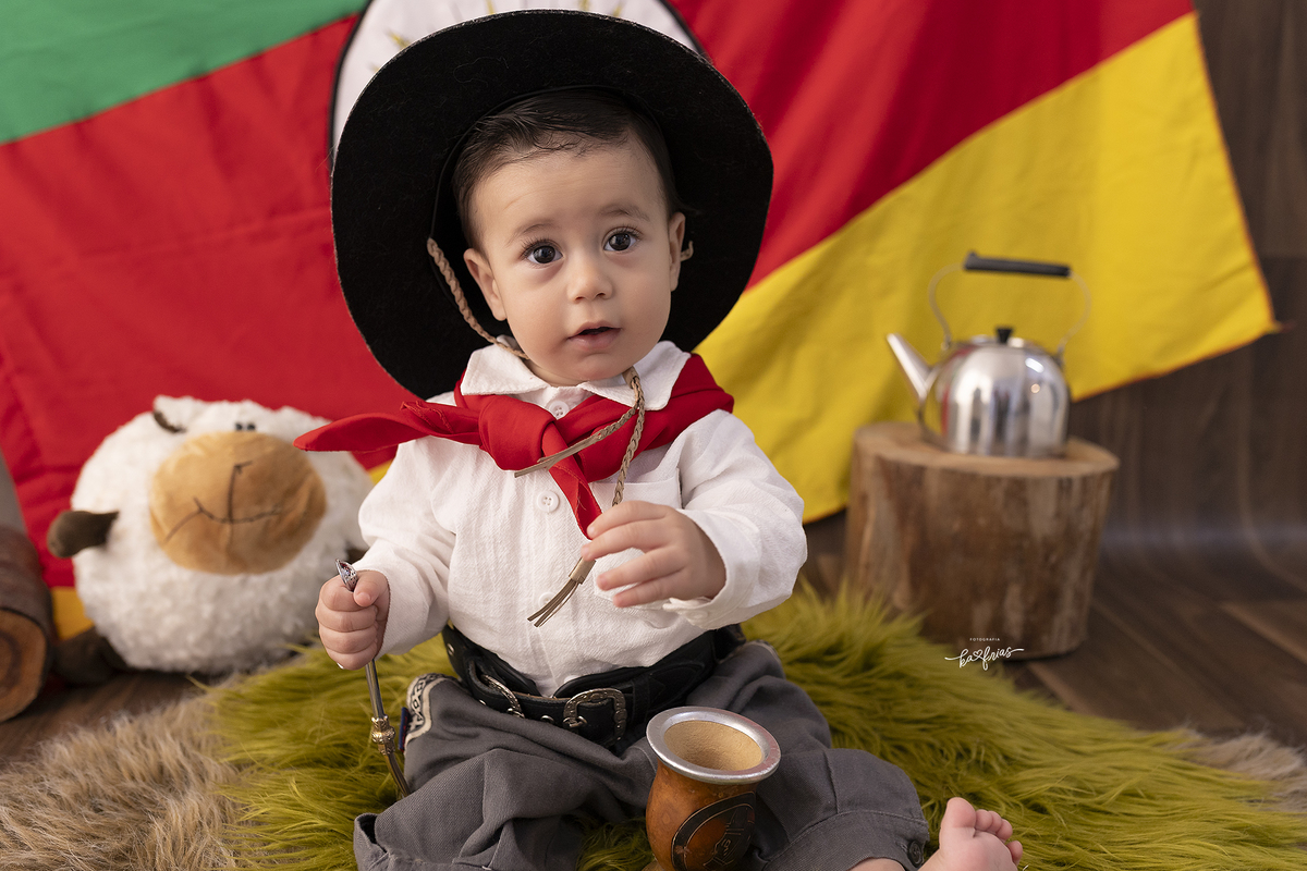 o bebe esta vestido de gaucho para as fotos mensais 