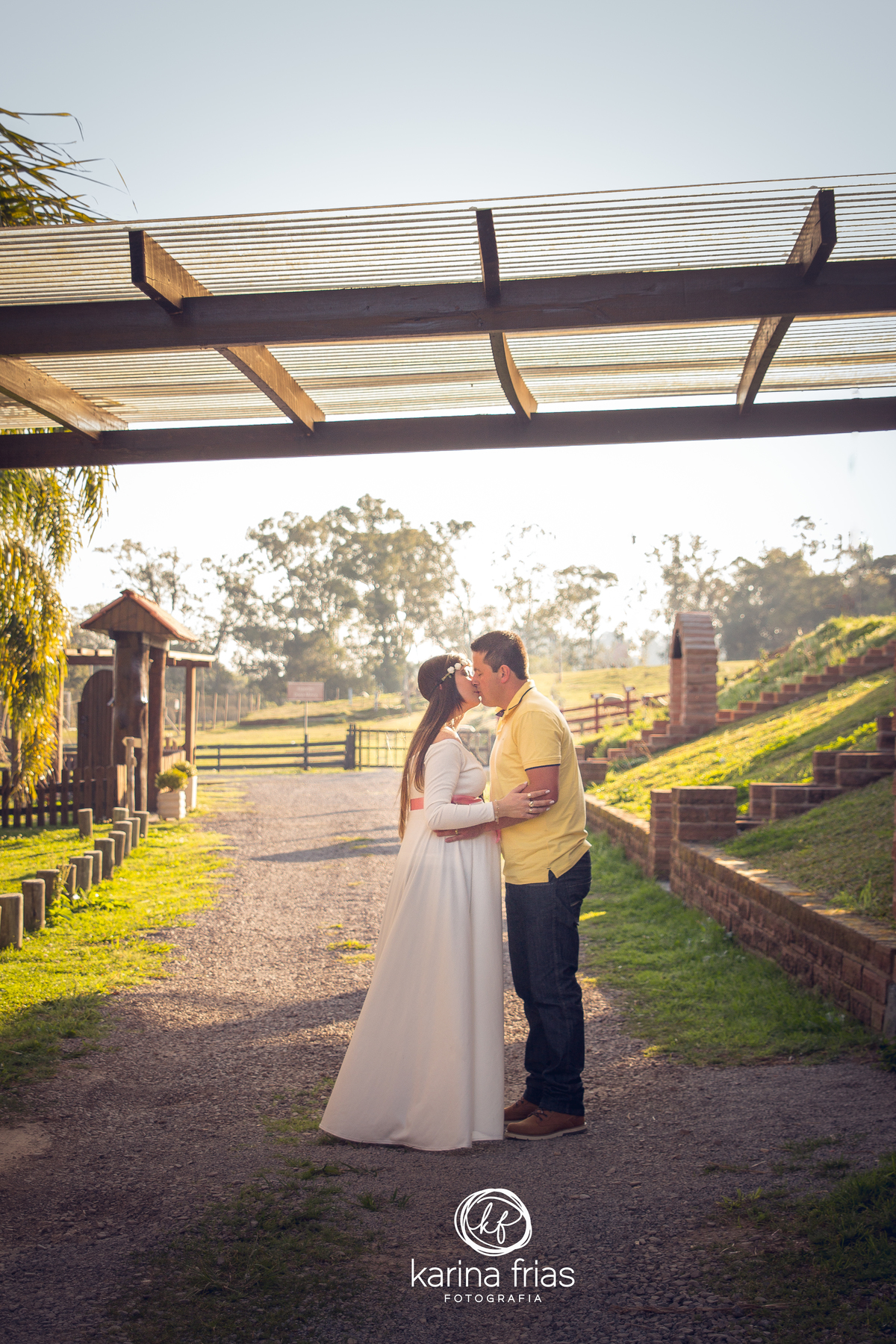casal se beija enquanto realizam o ensaio externo de gestante