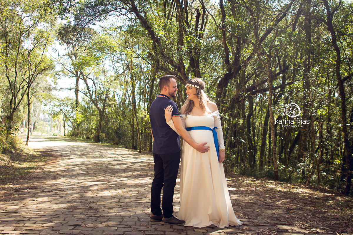 a mãe olha atenta o pai e posa para fotos de gestante