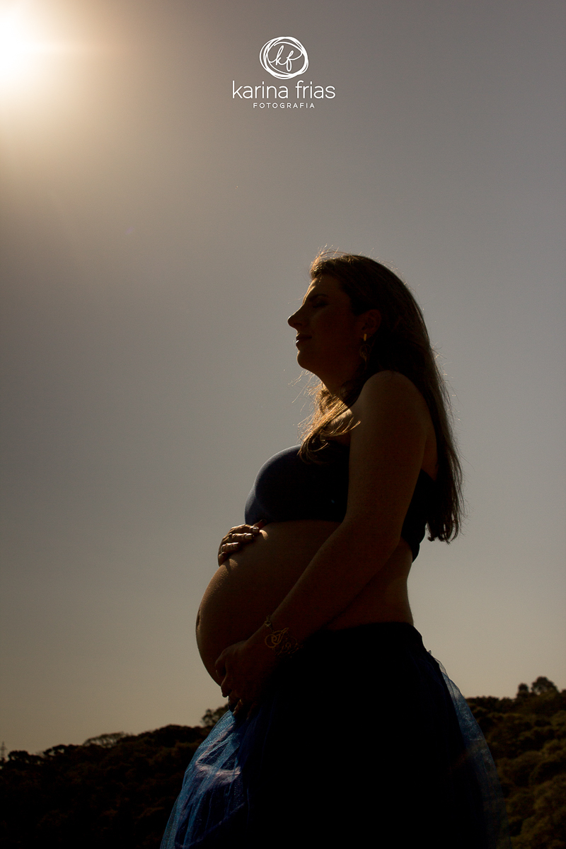 A mãe olha atenta o sol se pondo enquanto a fotógrafa registra a espera do filho