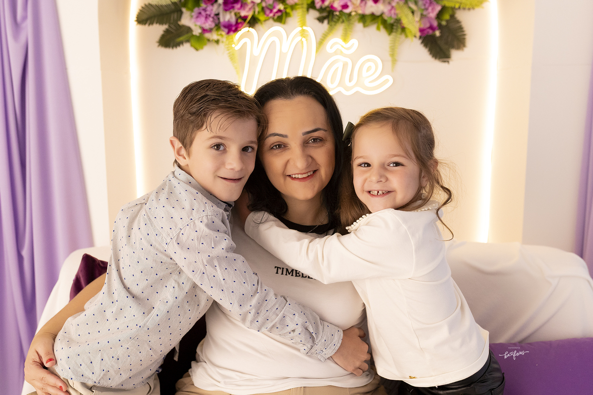os filhos abraçam a mae na sessão de fotos