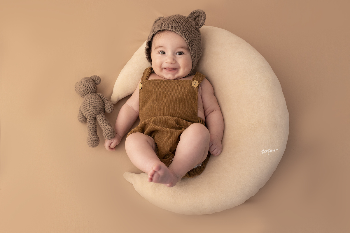 o bebe esta vestido de ursinho para suas fotos mensais