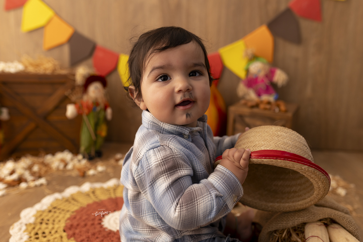 o bebe segura o chapeu na sessão de fotos infantis em caxias do sul