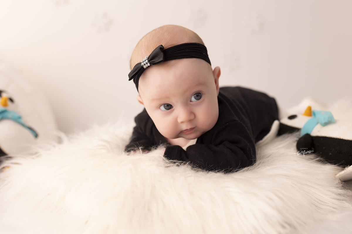 a bebe olha para os pais no ensaio de mesversario
