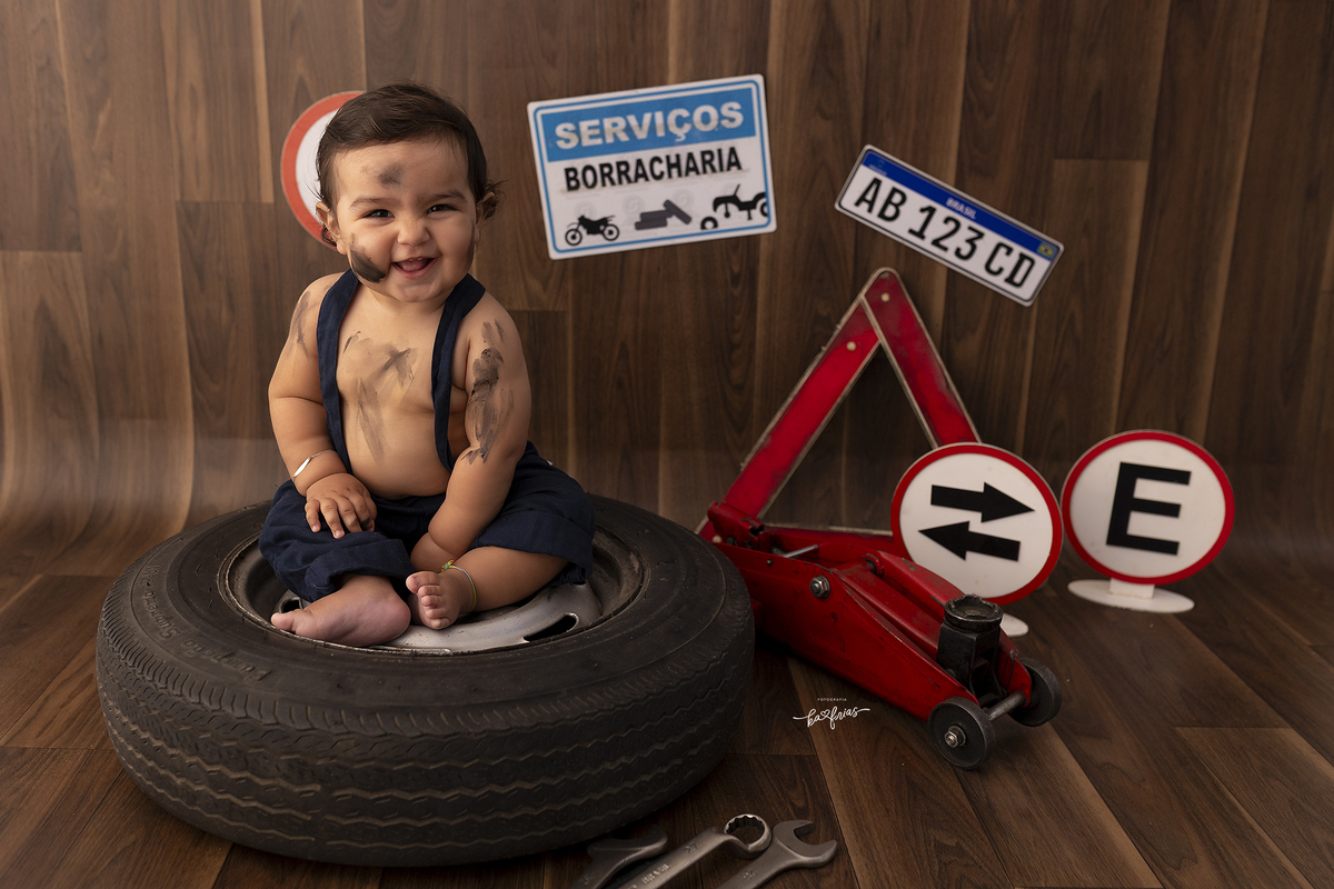 o bebe esta vestido de mecanico para as fotos mensais