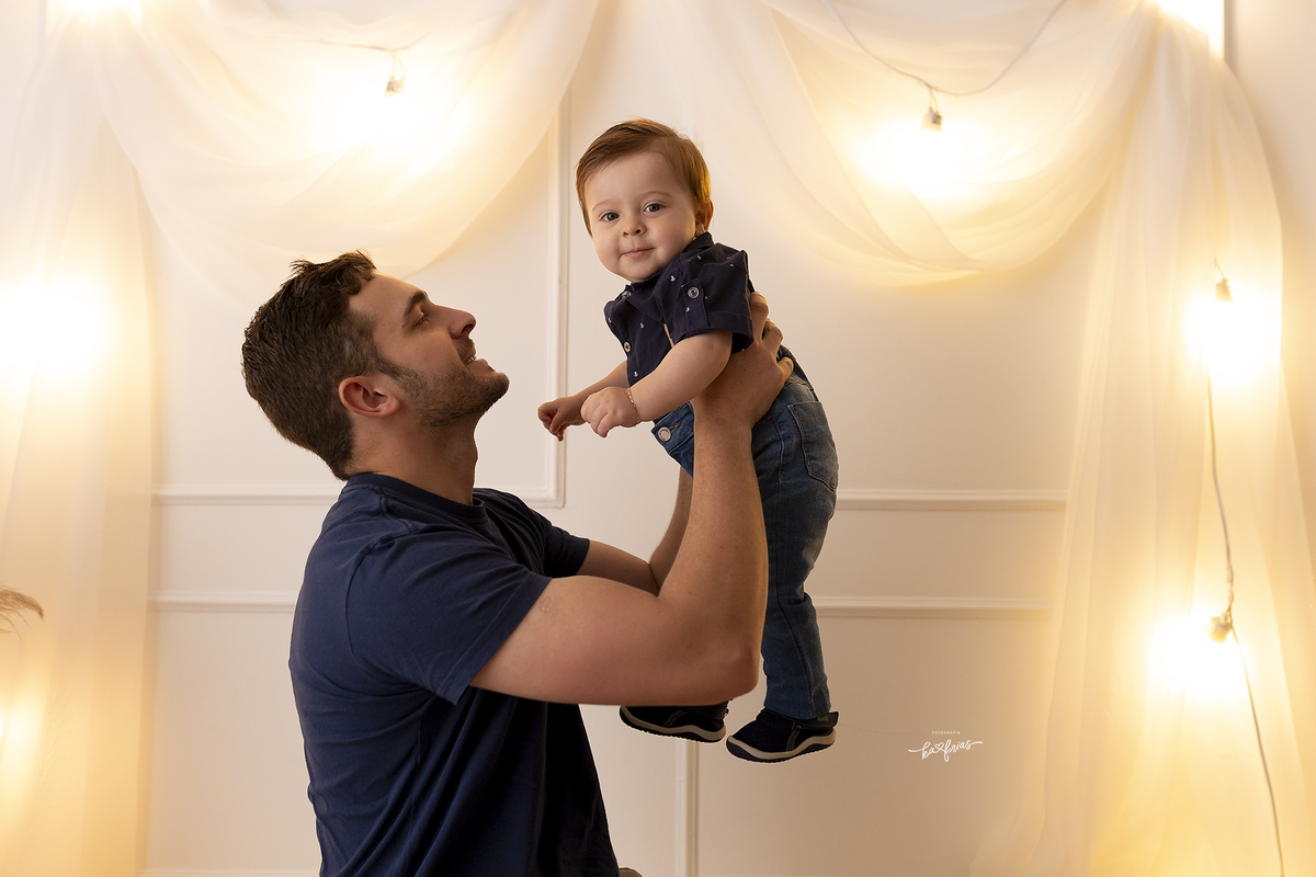 o pai olha para o bebe na sessão de fotos de dia dos pais