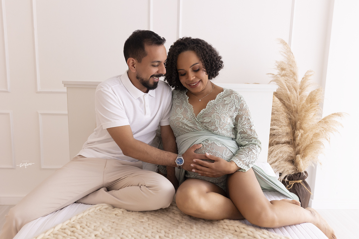 os pais olham para a barriga no ensaio gestante