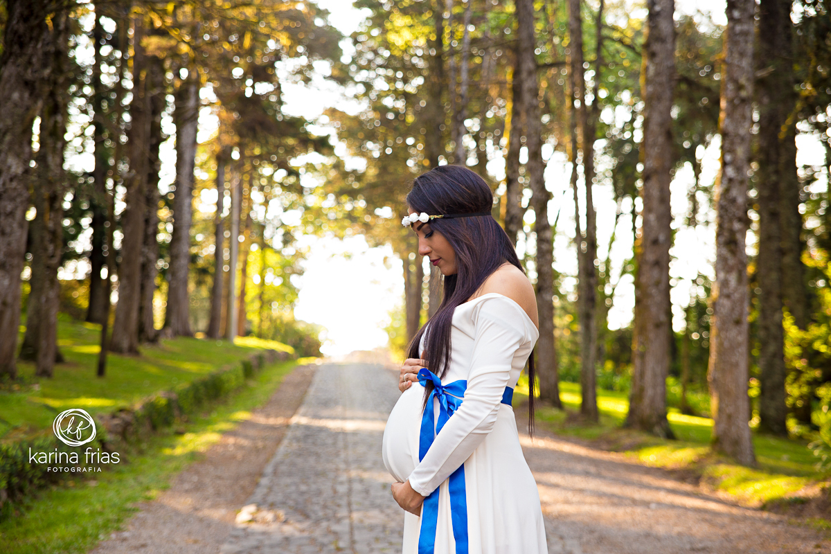 A GESTANTE OLHA SUA BARRIGA PARA AS FOTOS DO BOOK EXTERNO