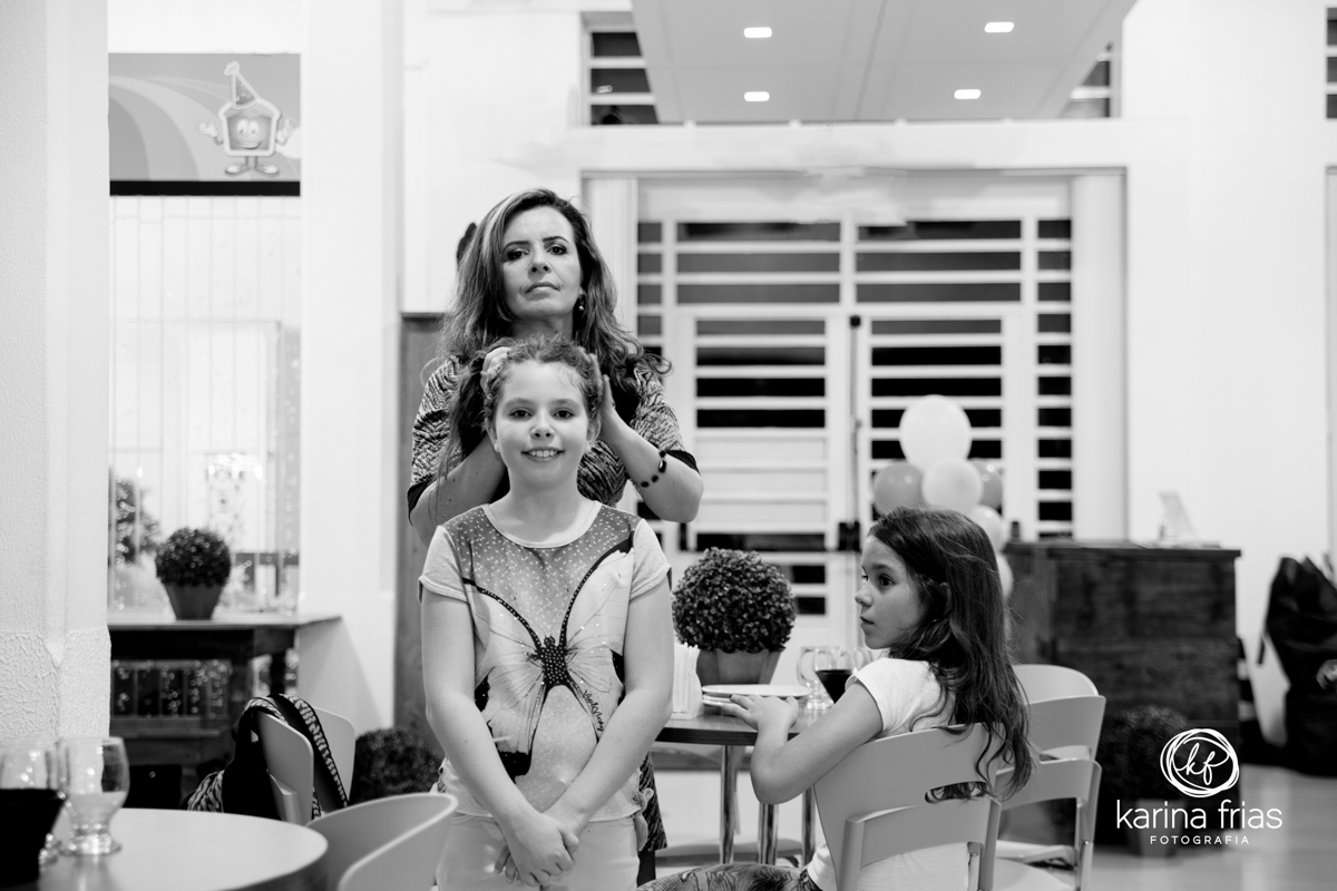 mae amarra o cabelo da filha para a fotografa de esta de aniversario