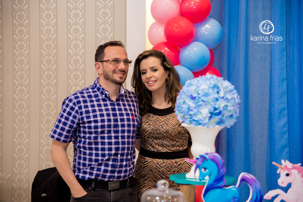 pais aguardam a chegada da aniversariante enquanto a fotografa de familia clica os dois