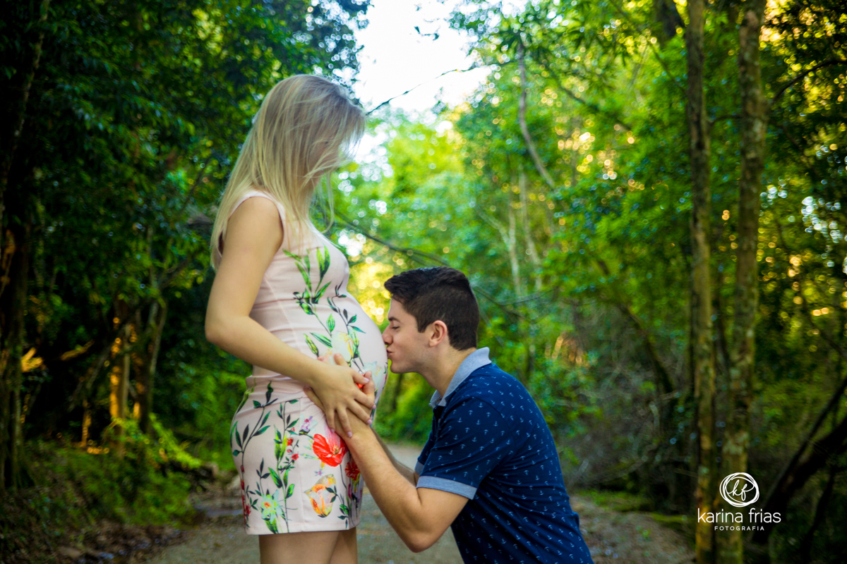 o pai beija a barriga no book de gestante da esposa