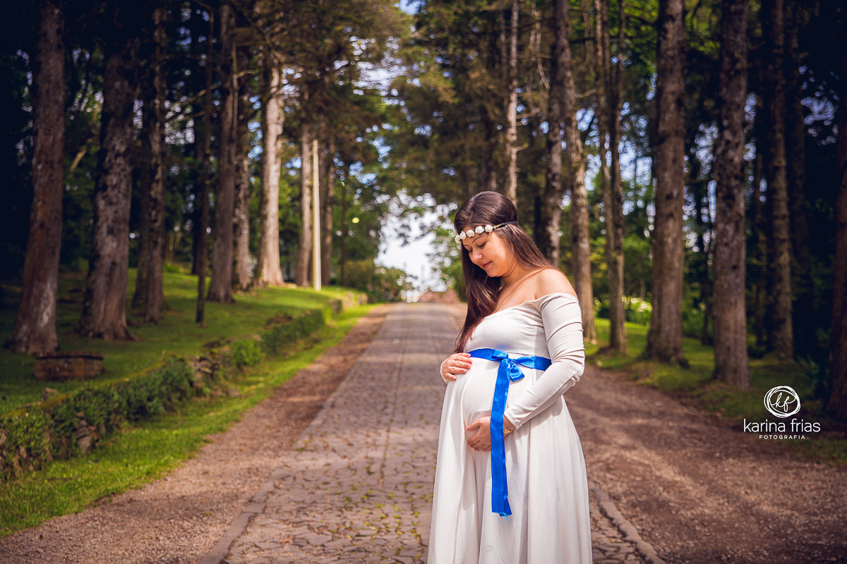 A GESTANTE OLHA PARA A BARRIGA EM SEU ENSAIO EXTERNO