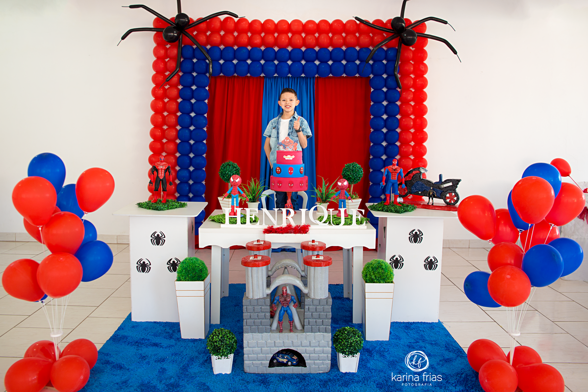 a criança esta em frente a mesa para as fotos do seu aniversario