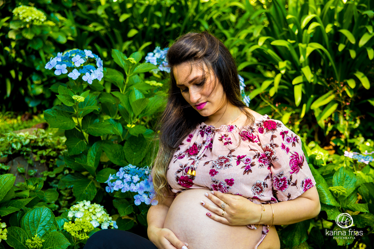 a gestante segura a barriga para as fotos do seu book de gestante