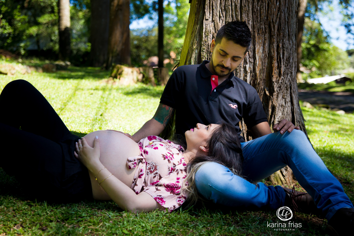 a gestante deita no colo do esposo para as fotos do book externo 