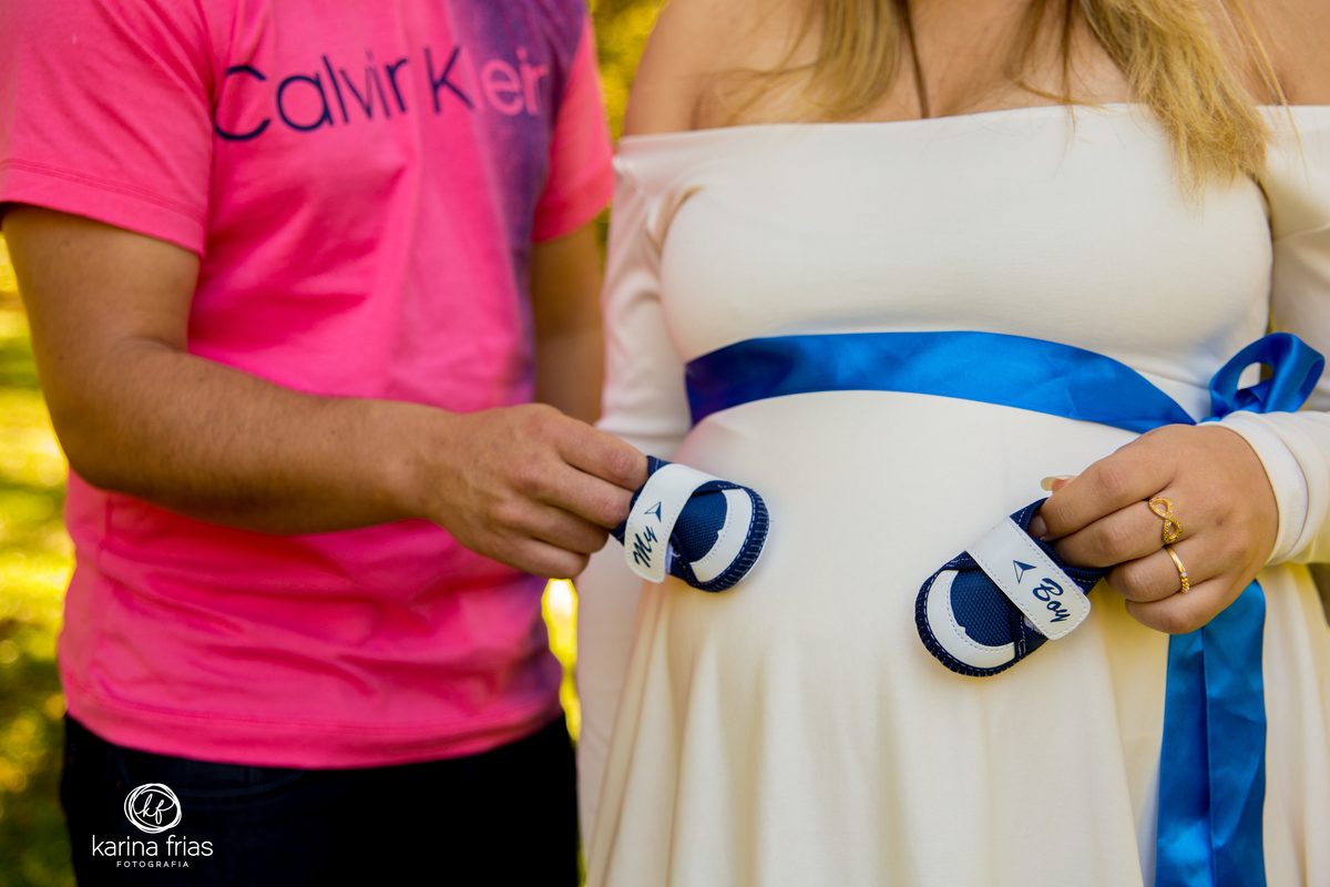 os pais colocam o sapatinho na barriga no ensaio gestante