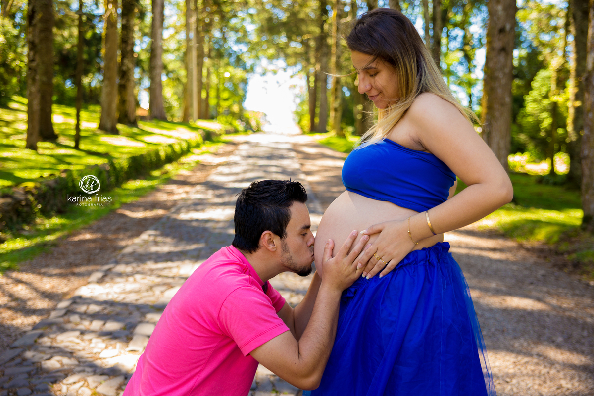 o pai beija a barriga da esposa nas fotos de gestante externas