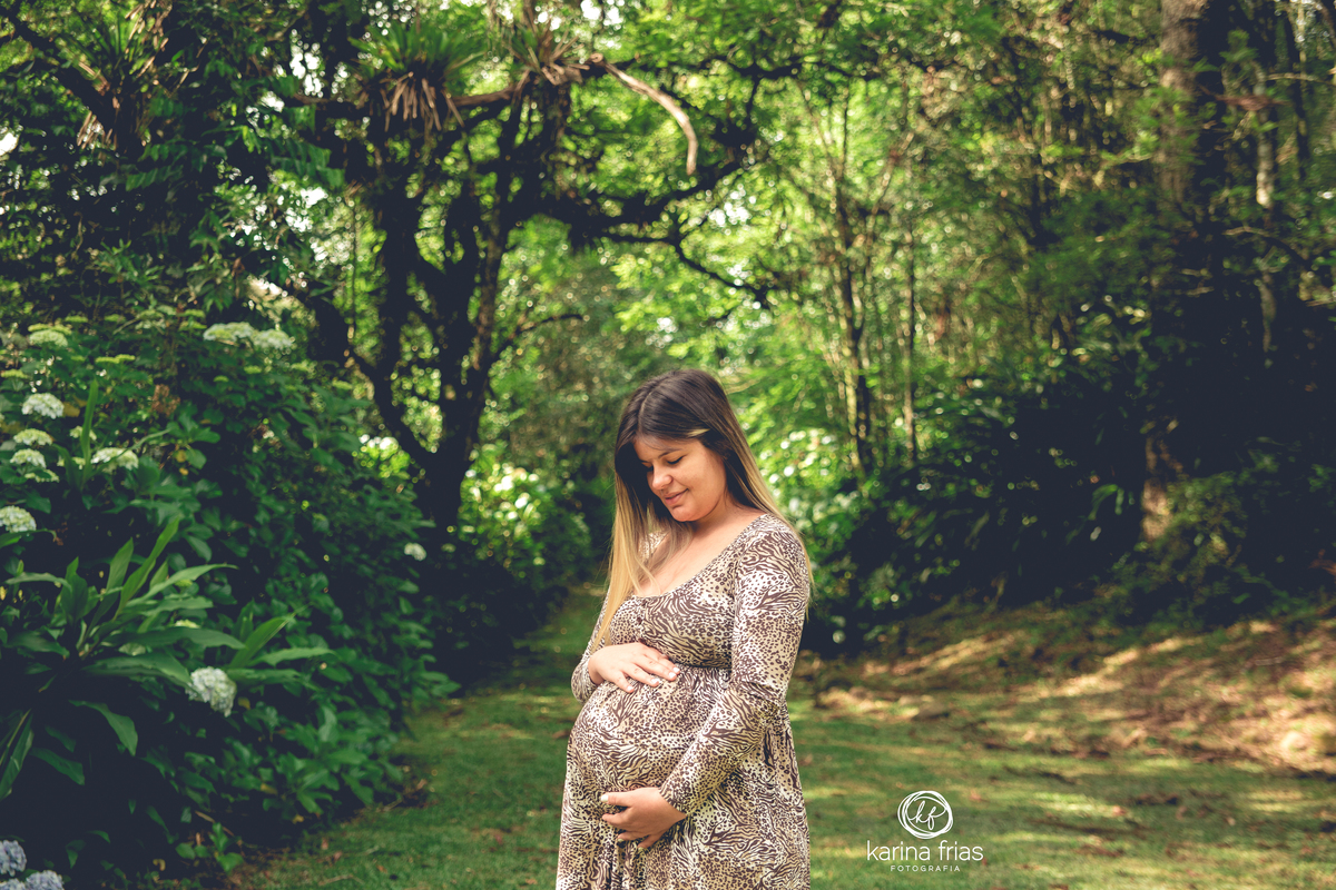a gestante olha para a barriga em fotos para o book 