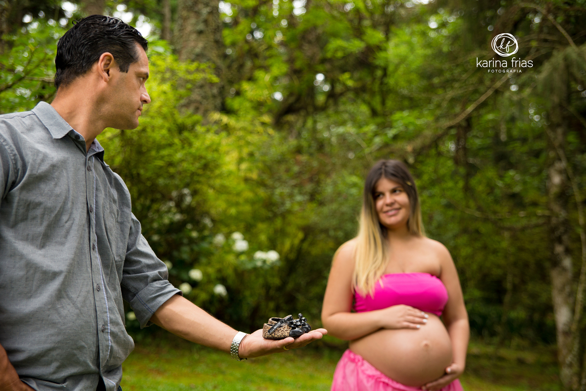 o pai mostra o sapatinho da filha no ensaio gestante