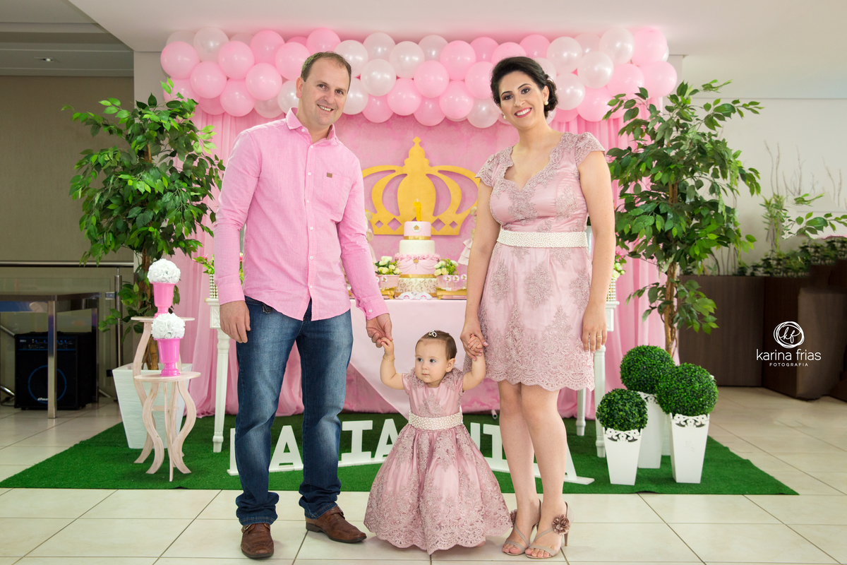 os pais posam frente a mesa do aniversário