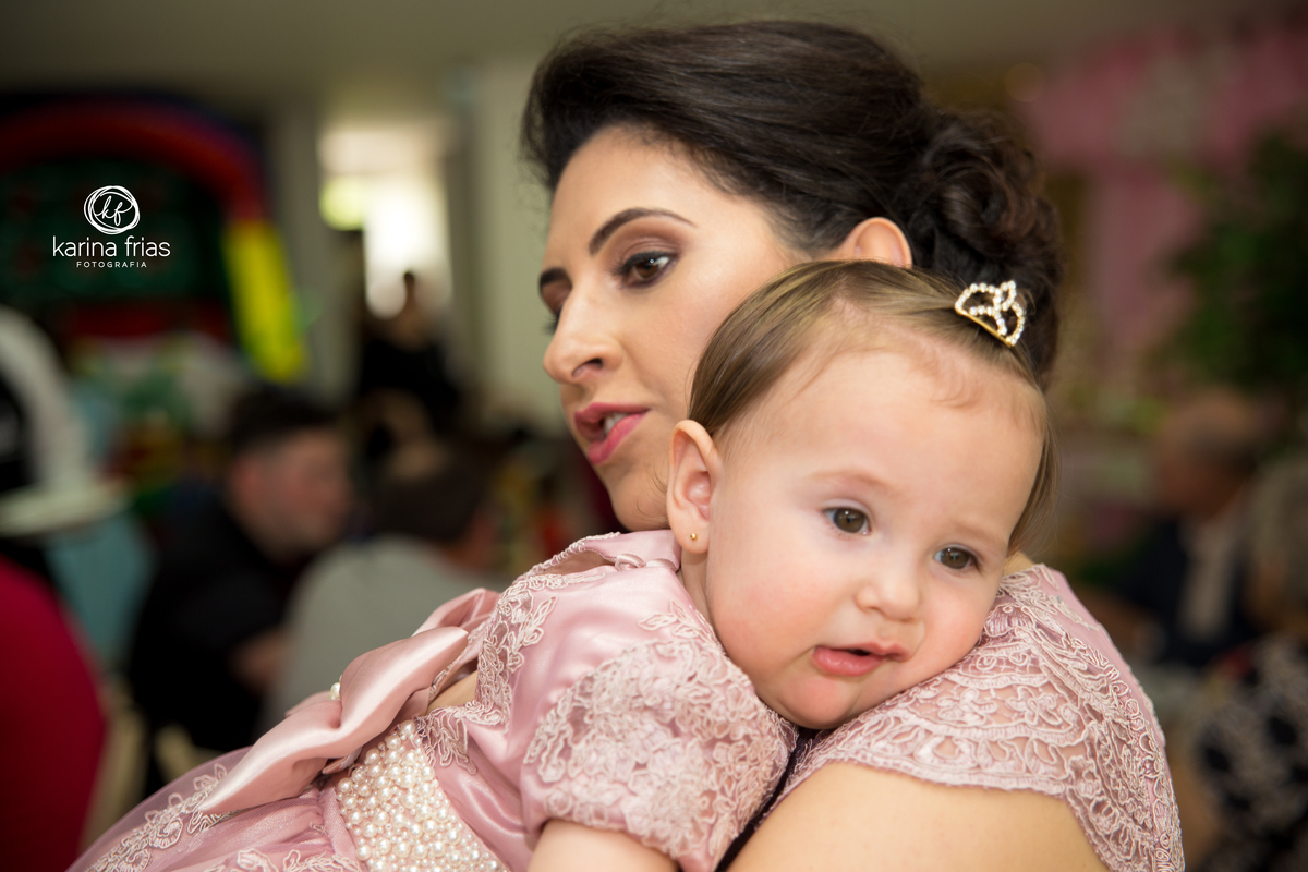 a criança está cansada no colo da mãe na festa de aniversário