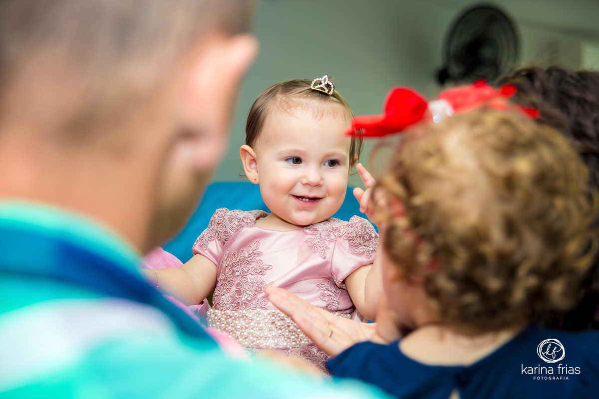 a criança está no colo dos convidados para as fotos do seu aniversário