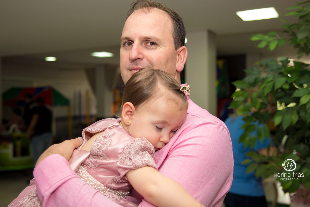 o pai segura a bebe que dorme na festa infantil