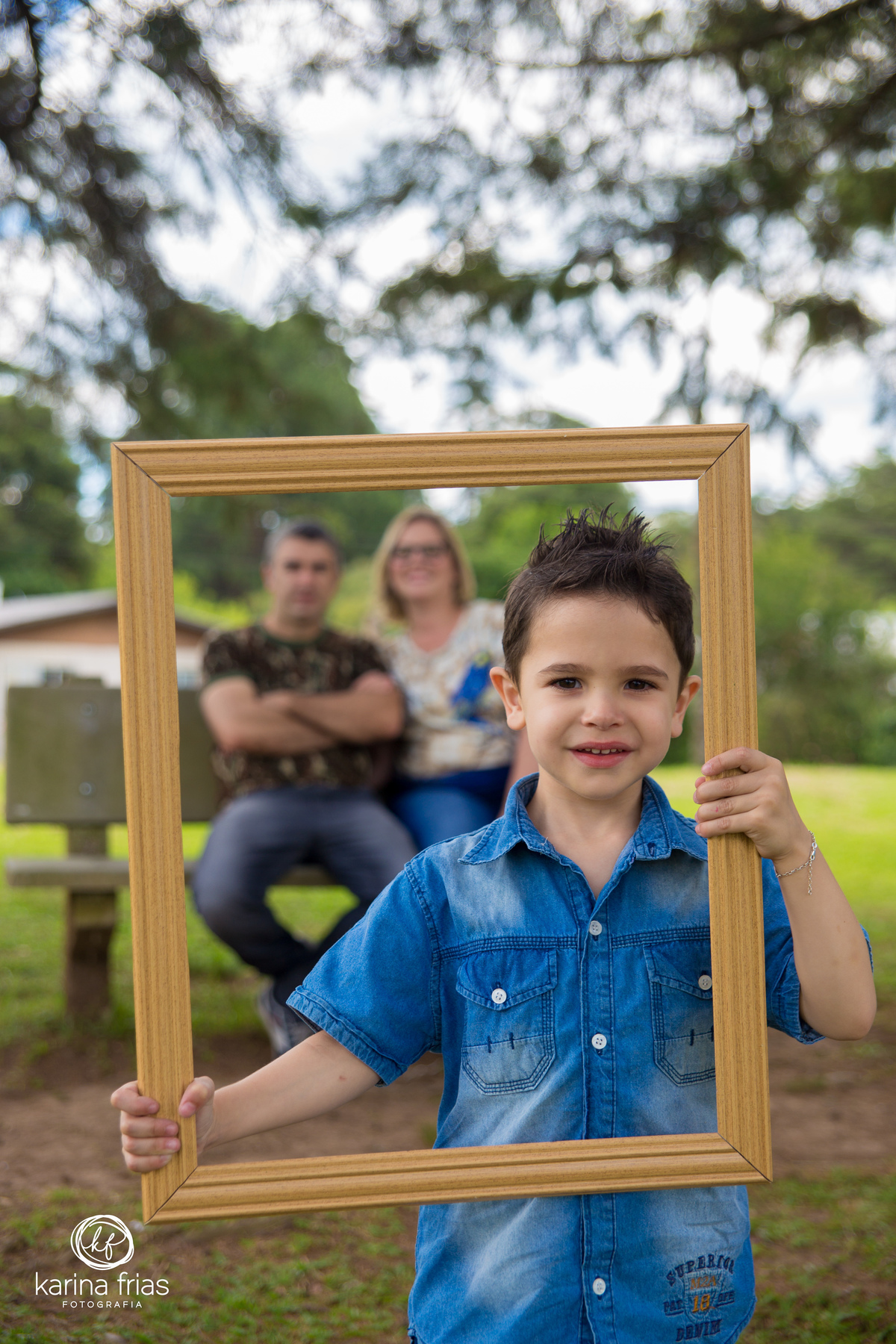 o filho segura o quadro para o ensaio externo de familia