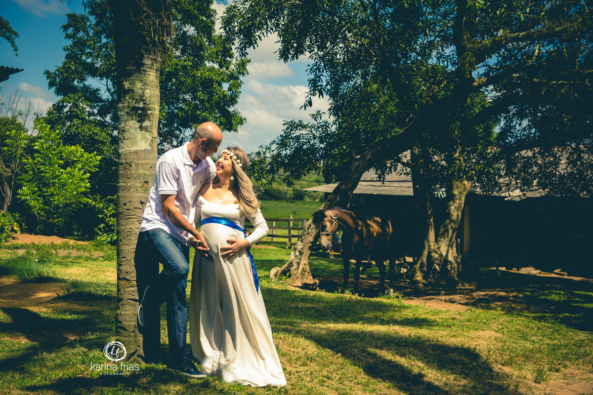 os pais fazem pose para o ensaio de gestante externo