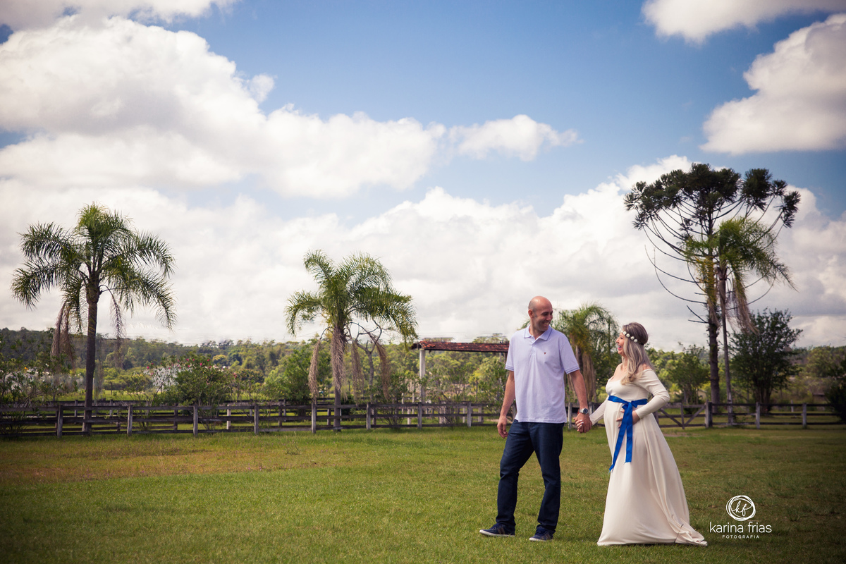 no ensaio de gestante, os pais caminham de mãos dadas
