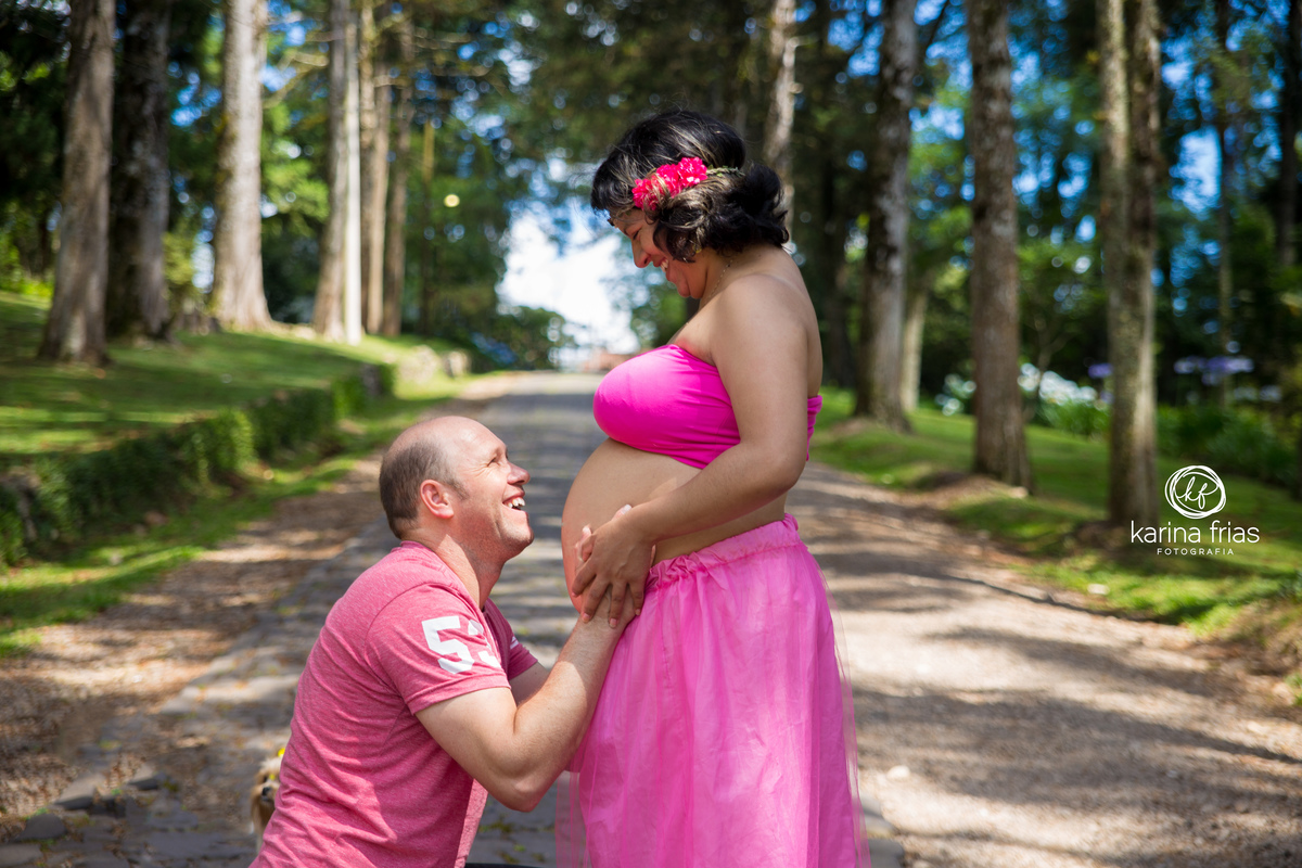 o pai olha atento á esposa para as fotos de gestante