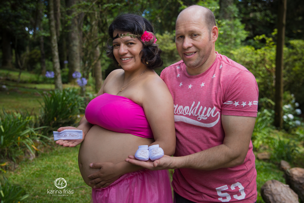 os pais seguram os sapatinhos do bebe no ensaio