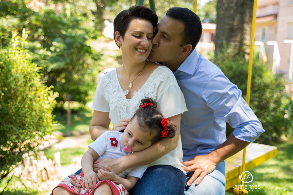 a criança ja esta cansada no ensaio de familia e o pai beija a mae