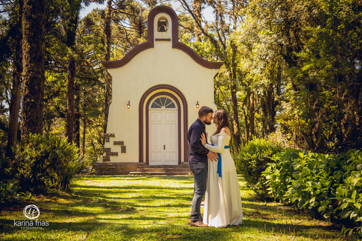 os pais se beijam frente a igreja para o ensaio externo de gestante