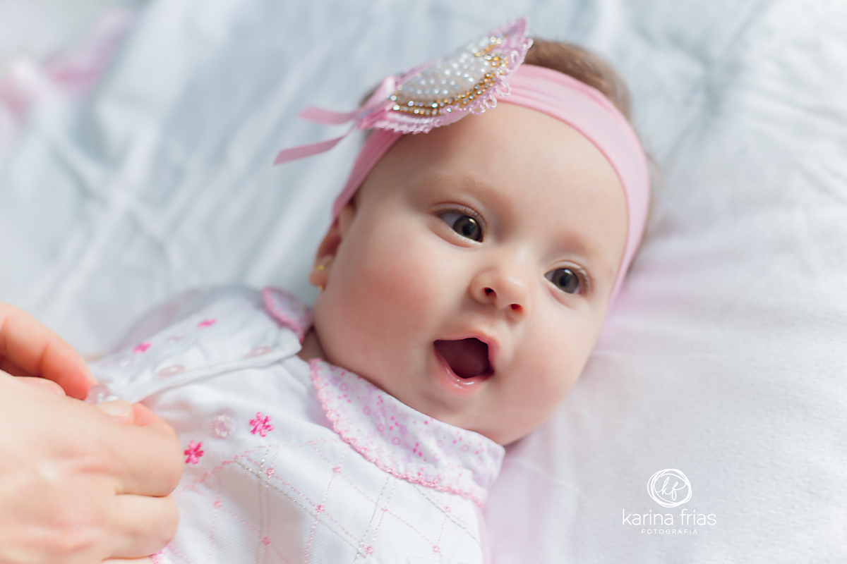A BEBE ESTA SENDO TROCADA ENQUANTO A FOTOGRAFA DE FAMILIA REGISTRA O MOMENTO