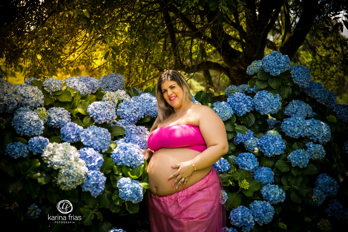 a mes acaricia as flores no seu ensaio externo de gestante