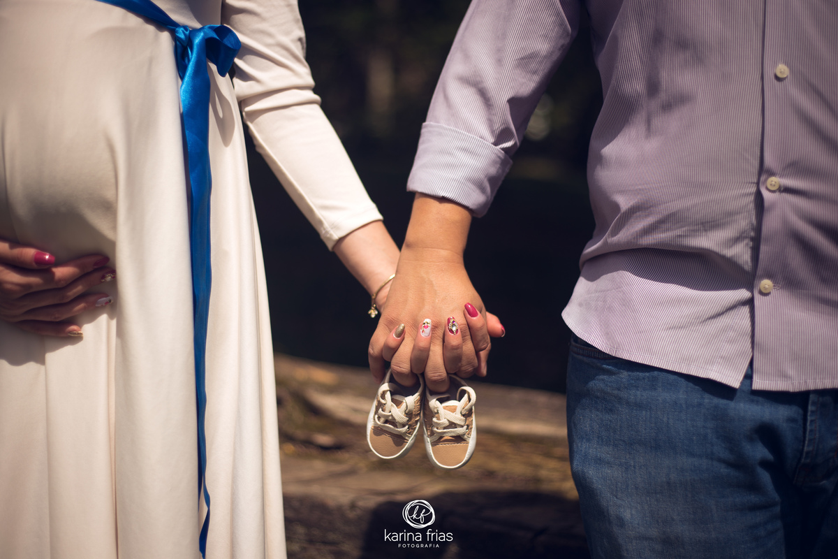 os pais seguram o sapatinho para as fotos do book de gestante